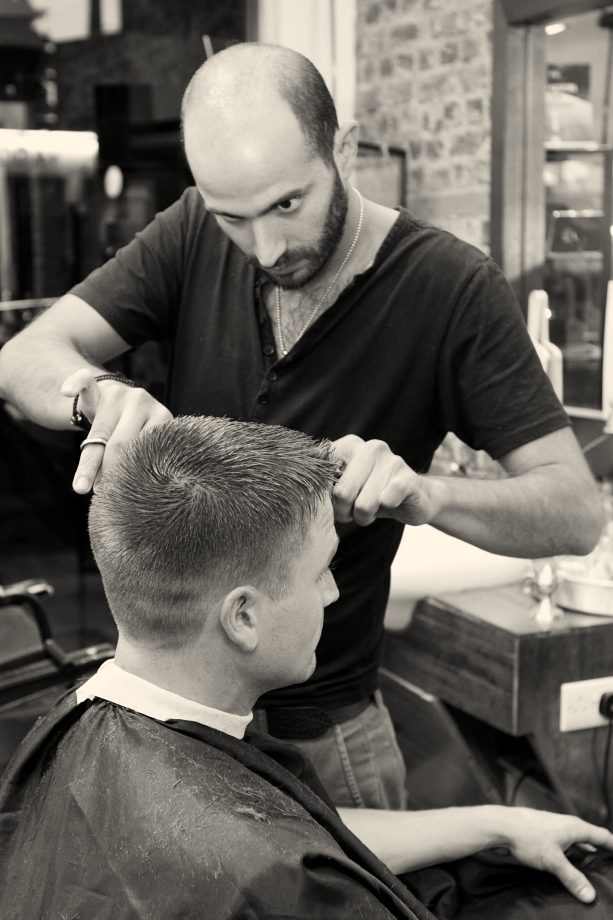 A barber checking the line of a cut