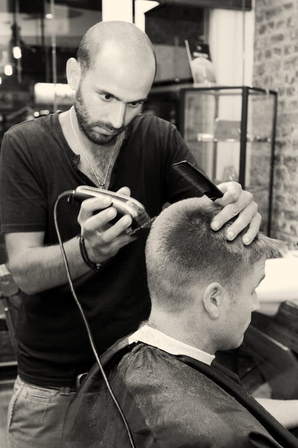 A barber working with clippers and comb