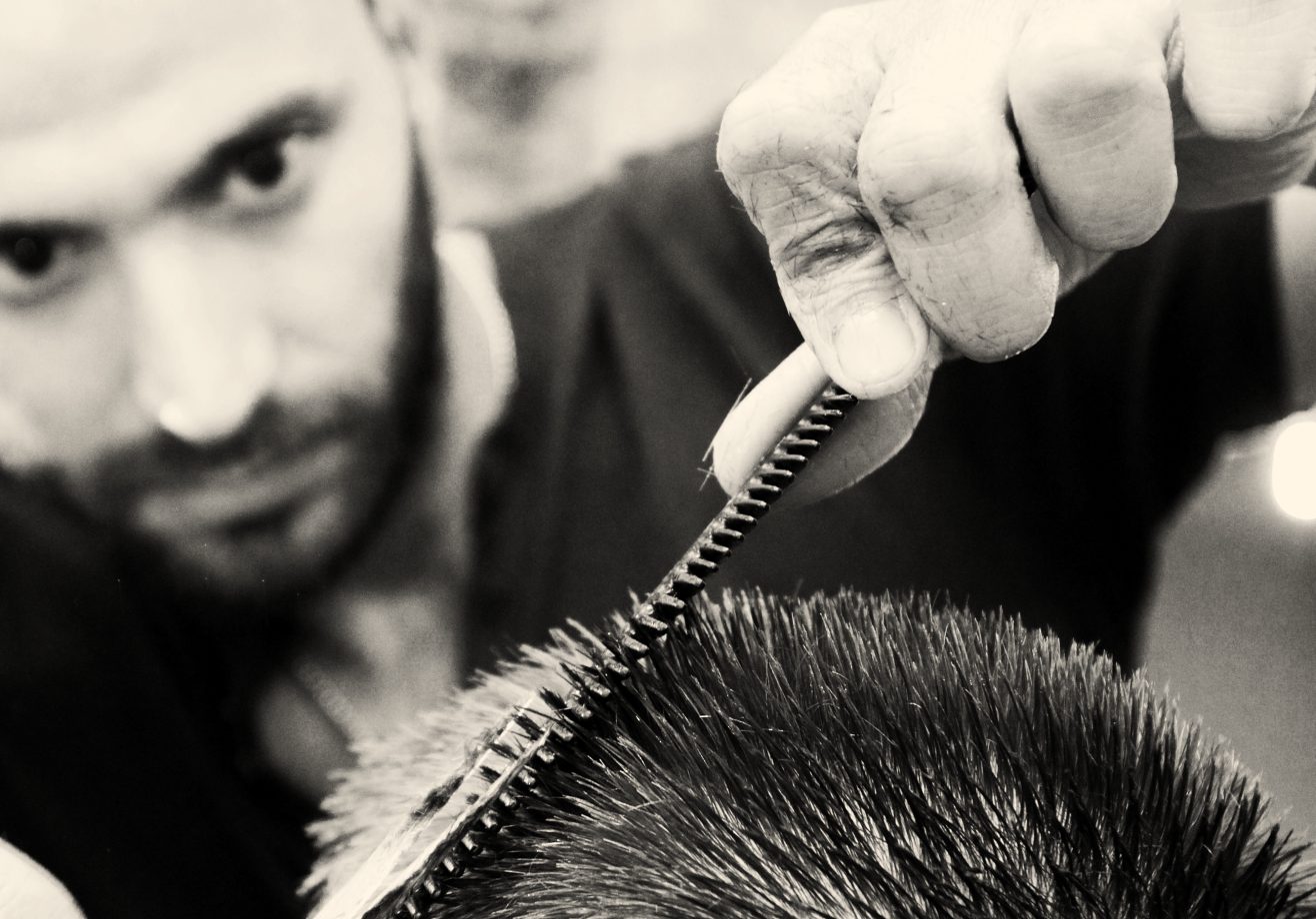 Close-up of a barber combing through a fresh cut