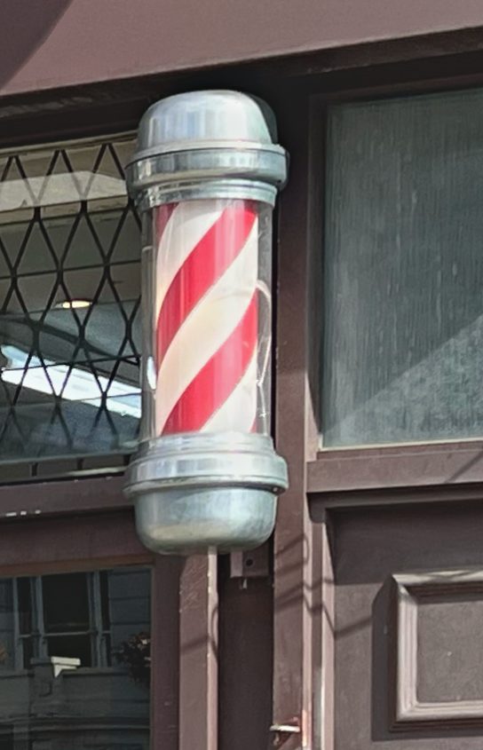 The red and white barber pole outside George's Barber Room, 324 Kentish Town Road